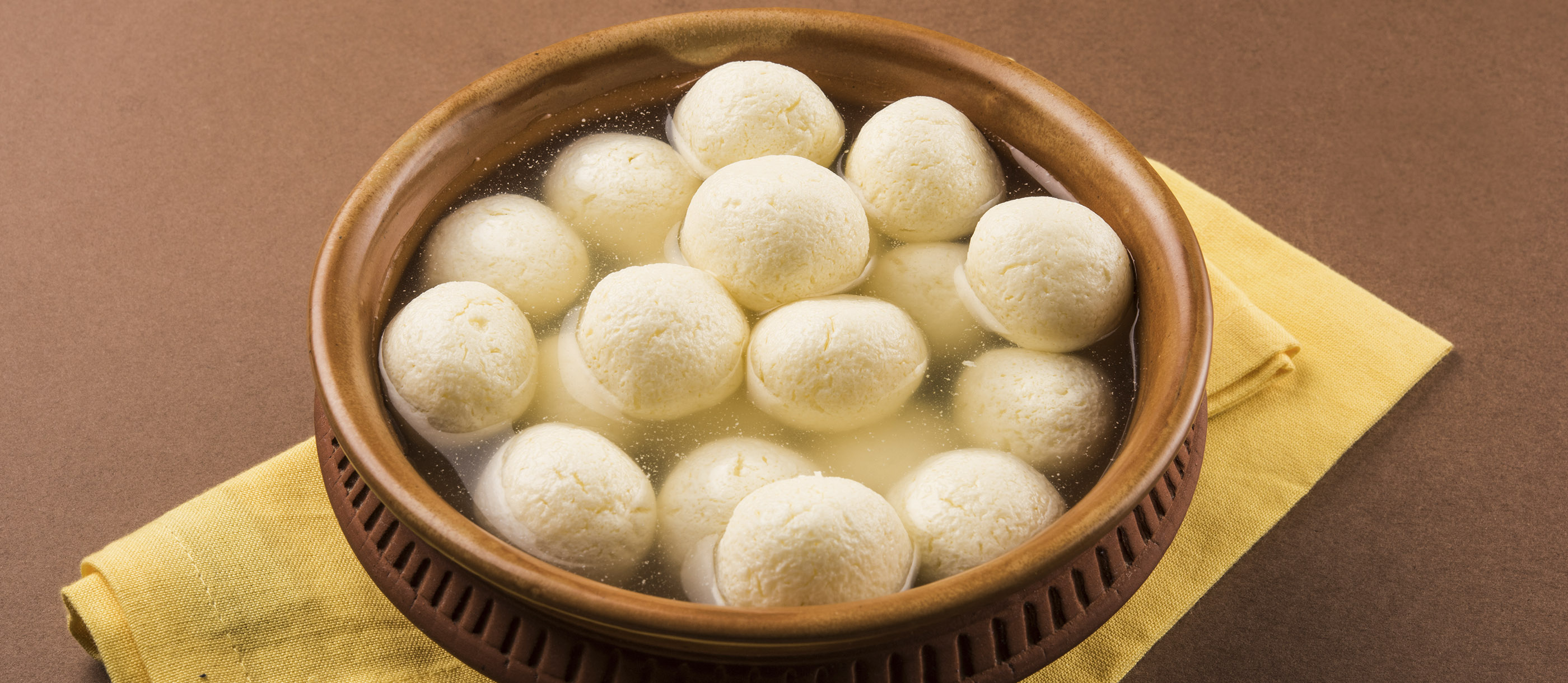 Indian Sweet - Rasgulla, Famous Bengali sweet in clay bowl with napkin on  pink background 5579140 Stock Photo at Vecteezy