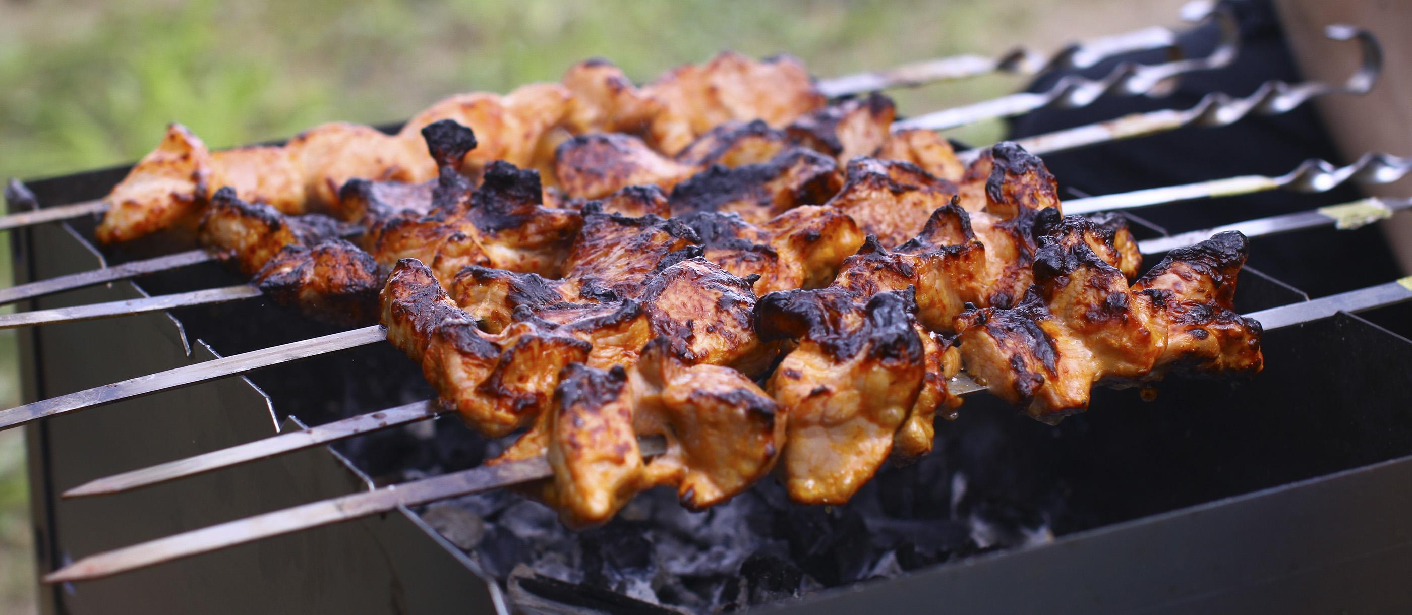 Grilling marinated shashlik on a grill. Shashlik is a form of Shish kebab  popular in Eastern, Central Europe and other places. Shashlyk (meaning  skewered meat) was originally made of lamb. Stock Photo