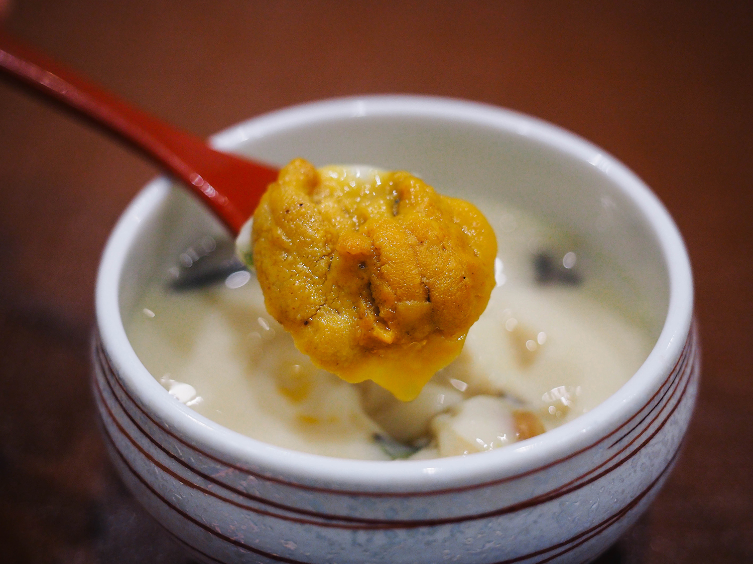 Sea Urchin Chawanmushi in a dish with chopsticks isolated on mat